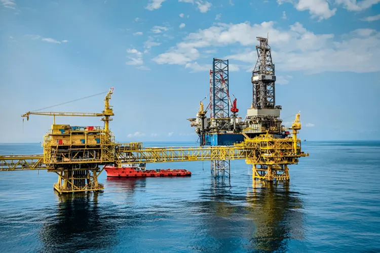 A vibrant offshore oil rig under a clear sky, reflecting in the calm blue sea
